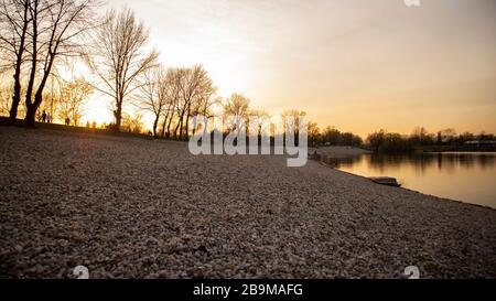 Persone sulla riva del lago jarun, godendosi il tramonto pochi giorni prima che il virus corona si blocchi a Zagabria e le riunioni sociali sono stati vietati Foto Stock