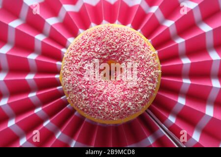 Ciambella con sfondo rosso aspersato, vista dall'alto Foto Stock