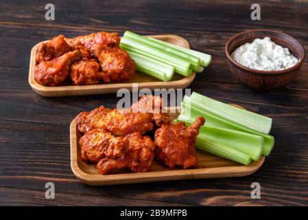 Due porzioni di ali di bufalo con gambi di sedano fresco e salsa di formaggio blu Foto Stock