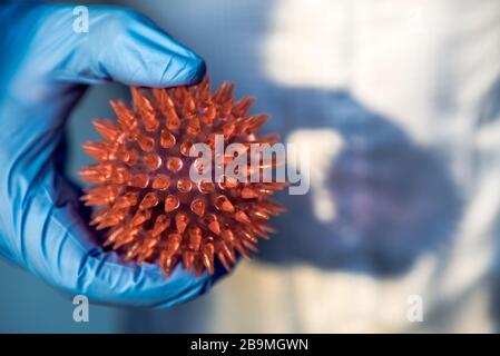 Mani di medico con il modello del virus Corona. Scientifico su tuta protettiva contenente un Coronavirus. Molecola astratta di un ceppo MERS-Cov virus. Io Foto Stock