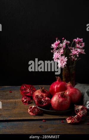 Diversi melograni su piastra su piastra di legno Foto Stock