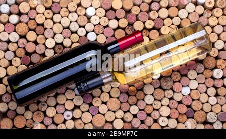 bottiglie di vino rosso e bianco sullo sfondo dei tappi di vino Foto Stock
