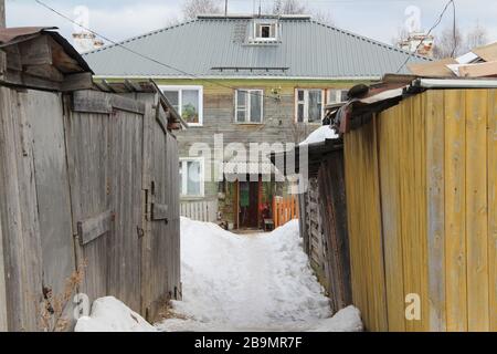 Casa di legno a due piani circondata da capannoni di legno in inverno russo sity. Illustrazione delle scorte per il Web e la stampa con spazio vuoto per testo e design. Foto Stock