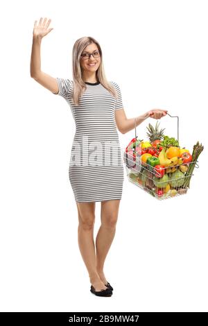 Ritratto a tutta lunghezza di una giovane donna con un cestino con frutta e verdure ondeggianti isolato su sfondo bianco Foto Stock