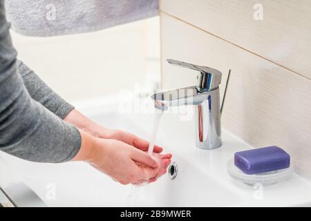 Lavaggio a mano con sapone sopra il lavandino in bagno, closeup. Foto Stock