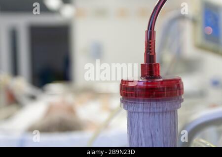 Dializzatore con porta superiore, su paziente in backgroud a letto collegato a un ventilatore medico in terapia intensiva in ospedale Foto Stock