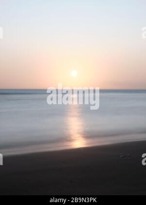 Una lunga vista di impronte umane camminare al tramonto sulla spiaggia di Solanas, Punta Ballena, Maldonado, Uruguay Foto Stock