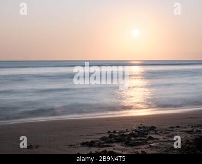 Una lunga vista di impronte umane camminare al tramonto sulla spiaggia di Solanas, Punta Ballena, Maldonado, Uruguay Foto Stock