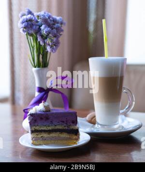 Una tazza di caffè con torta. Sfondo bianco. Caffè del mattino con latte. Foto Stock