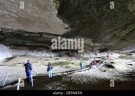 Persone all'interno della grotta di Mylodon (monumento naturale Cueva del Milodon), città di Puerto Natales, Patagonia, Cile, Sud America Foto Stock