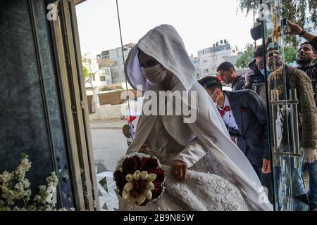 I palestinesi camminano nei pressi di un murale raffigurante il compianto leader palestinese Yasser Arafat a Rafah, nella striscia meridionale di Gaza, il 11 novembre 2021. Foto Stock