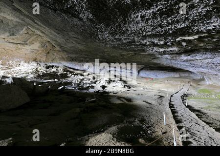 Persone all'interno della grotta di Mylodon (monumento naturale Cueva del Milodon), città di Puerto Natales, Patagonia, Cile, Sud America Foto Stock