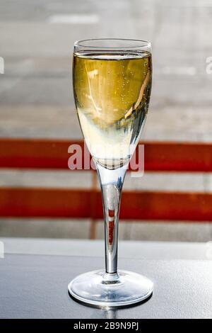 Bicchiere di champagne al tavolo in una sala business dell'aeroporto isolata su uno sfondo burred Foto Stock