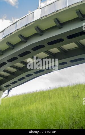 Ponte ad arco su una strada costeggiata da palme con pedone a piedi in un giorno blu perfetto Foto Stock