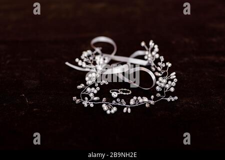 Accessorio della sposa. Anello di aggancio in oro bianco con diamante e accessori per capelli su sfondo nero. Messa a fuoco selettiva Foto Stock