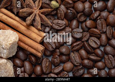 Composizione di caffè e zucchero di canna su fondo di pietra con aggiunta di anice, cannella e zucchero di canna. Foto Stock