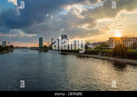 Francoforte sul meno con il ponte pedonale Holbeinsteg, la barca turistica e la passeggiata lungo il fiume meno al tramonto con il cielo spettacolare. Francoforte è il fi Foto Stock