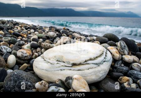 Tranquilla Rocky Beach Scene: Primo piano di roccia bianca su Hualien Beach al tramonto - Hualien County, Taiwan Foto Stock