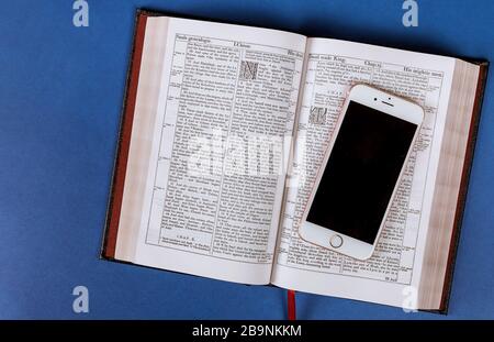 24 MARZO 2020 SAYREVILLE NJ: Apre la Bibbia con cellulare su un audiolibro religioso Foto Stock