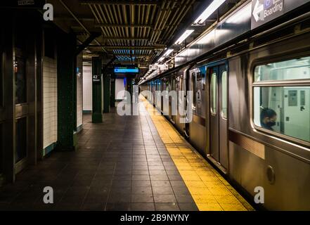 L'impatto di Covid-19 su NYC ha causato la chiusura di molte aziende. Le strade sono vuote e le persone che praticano la distanza sociale. Foto Stock