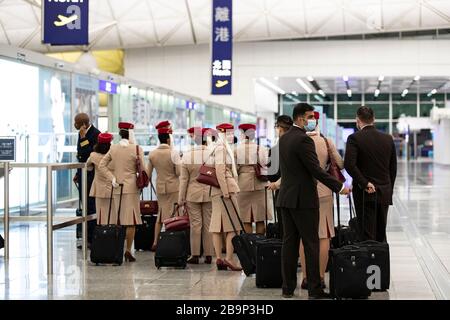 I membri dell'equipaggio della compagnia aerea Emirates sono visti lasciare l'aeroporto internazionale di Hong Kong.temporalmente 14 giorni nuove misure in risposta all'ultima situazione del COVID-19 sono iniziate il 25 marzo 2020, compresa la quarantena obbligatoria per i residenti di HK; Ferma l'ingresso per i non residenti di Hong Kong dall'estero e sospendi tutti i servizi di transito insieme al servizio limitato fornito dai negozi e dai ristoranti dell'aeroporto. Foto Stock