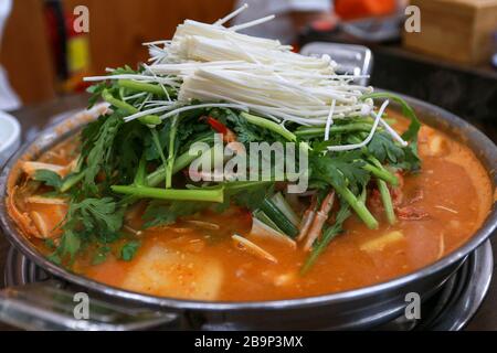 Cucina tradizionale coreana zuppa di granchio piccante con funghi enoki e verdure su un grande piatto Foto Stock