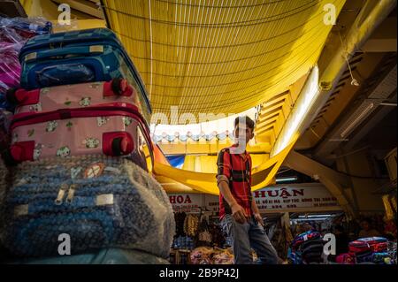 Uomo al suo stand a Binh Tay Market, ho Chi Minh, Vietnam Foto Stock