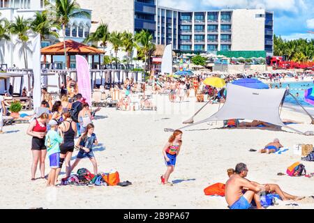 Playa del Carmen, Messico - 26 dicembre 2019: Spiaggia affollata piena di gente che gioca e prende il sole a Playa del Carmen nella Riviera Maya sui Caraibi Foto Stock