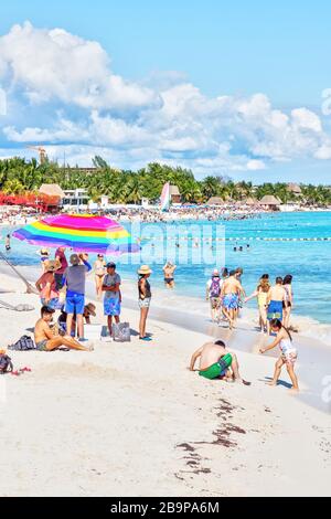 Playa del Carmen, Messico - 26 dicembre 2019: Spiaggia affollata piena di gente che gioca e prende il sole a Playa del Carmen nella Riviera Maya sui Caraibi Foto Stock