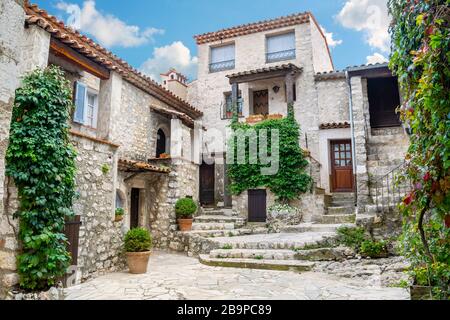 Un tipico vicolo cieco con pittoresche case in pietra nel borgo medievale murato in cima alla collina di Gourdon, Francia, nella zona delle Alpi Marittime. Foto Stock