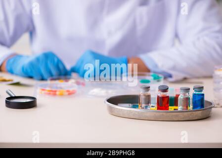 Giovane assistente di laboratorio maschile nel concetto di sintesi del farmaco Foto Stock
