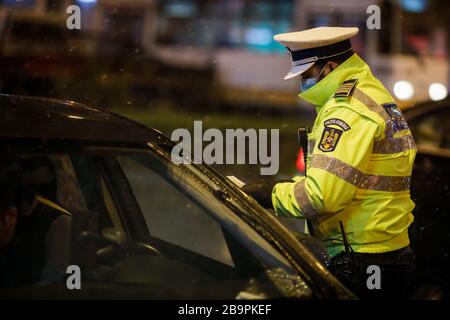 Bucarest, Romania - 23 marzo 2020: La polizia controlla i piloti e le loro carte durante il coprifuoco nelle strade di Bucarest in mezzo alla diffusione del CO Foto Stock