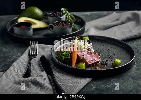 Bistecca di tonno con verdure su piatto, tonno fresco affettato, con verdure alla griglia. Autentica cucina giapponese Foto Stock