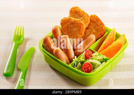 Scatole per il pranzo al sacco riempite di hash brown, salsicce da cocktail, frutta d'arancia e insalate, pronte per essere consumate per le attività Foto Stock