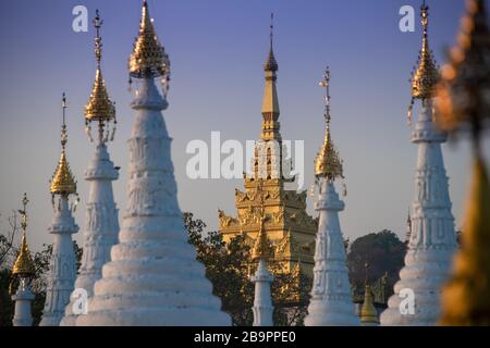 Sandamuni Pagoda, Mandalay, Myanmar. Stupa in oro e bianco con luccicanti HTi ornamentali o ombrello come cime su sfondo blu cielo Foto Stock