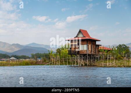 Lago Inle, Myanmar - Gennaio 2020: Tipico shack su palafitte, circondato da colture che sono coltivate su isole galleggianti artificiali intorno al lago Inle. Foto Stock