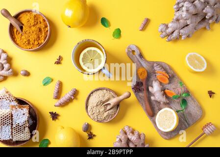 Concetto di assistenza medica. Raffreddore, trattamento influenzale. Zenzero, limone, miele, pillole, farmaci, integratori, termometro su sfondo giallo. Holi naturali alternativi Foto Stock