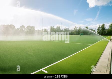 Il campo sportivo viene innaffiato da un impianto sprinkler Foto Stock