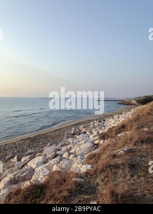 Alba sulla riva del mare, calda luce del sole Foto Stock