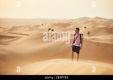 Avventura nel deserto. Uomo in piedi sulla duna di sabbia. Abu Dhabi, Emirati Arabi Uniti Foto Stock