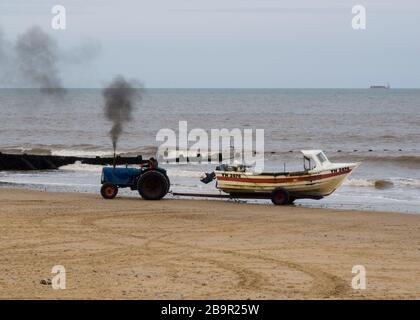 Crammer pescatore tirando in barca la spiaggia su rimorchio tirato da un trattore, Cromer, Norfolk, Regno Unito Foto Stock