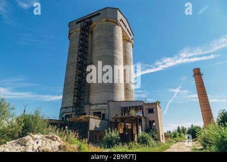 Vecchia fabbrica abbandonata overgrown di cemento armato. Foto Stock