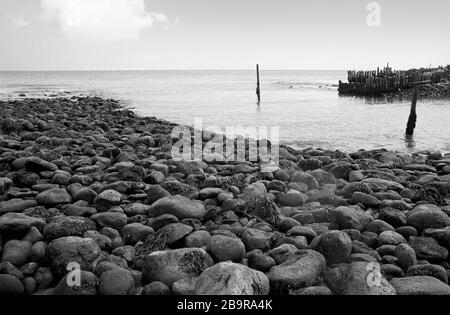 Castle Haven, Reeth Bay, Isola di Wight, Inghilterra, Regno Unito: Guardando fuori sul canale inglese in una giornata tranquilla, con una vecchia frangiflutti a metà distanza. Fotografia a pellicola in bianco e nero Foto Stock