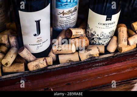 Atene, Grecia - 18 febbraio 2020. Bottiglie di vino e tappi di tappi usati da diversi paesi produttori di vino in una vetrina Foto Stock