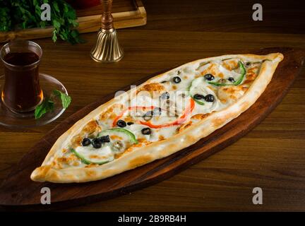 Pide vegetariano turco con verdure su pide di legno da tavola con cucina turca vegetale Foto Stock