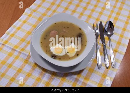 Cucina tradizionale polacca - zuppa acida bianca con uova e salsiccia bianca. Foto Stock