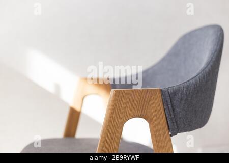 Moderna poltrona da cucina con mobili in legno gambe. Vista ravvicinata con messa a fuoco morbida Foto Stock