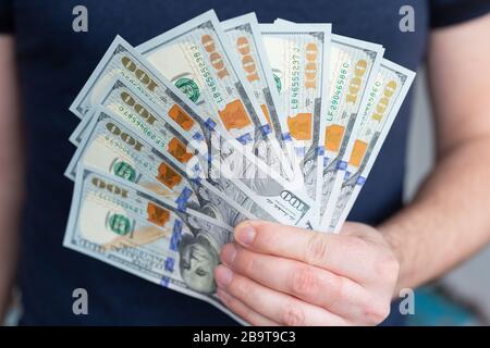 Dollari nelle mani dell'uomo. Profitti, risparmi. Successo, motivazione, flussi finanziari, ricchezza. Pila di dollari. 100 dollari usa Foto Stock