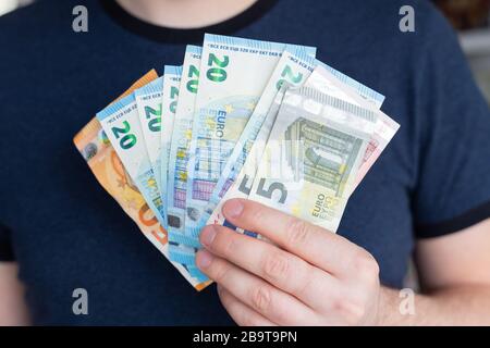 Euro nelle mani dell'uomo. Profitti, risparmio successo, motivazione, flussi finanziari, ricchezza. Stack di euro crisi mancanza di denaro Foto Stock