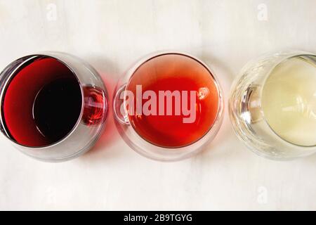 Varietà di vino. Rosso, rosa e vino bianco in Old fashion occhiali. Marmo bianco dello sfondo. Laici piana, spazio Foto Stock
